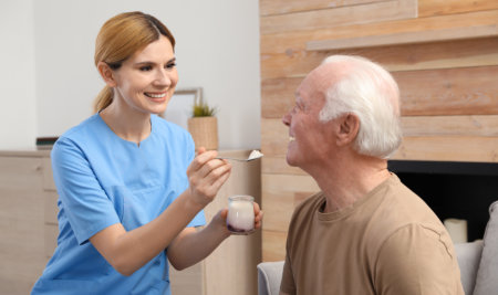 aide feeding an elderly man