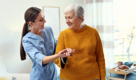 aide and elderly woman smiling at each other