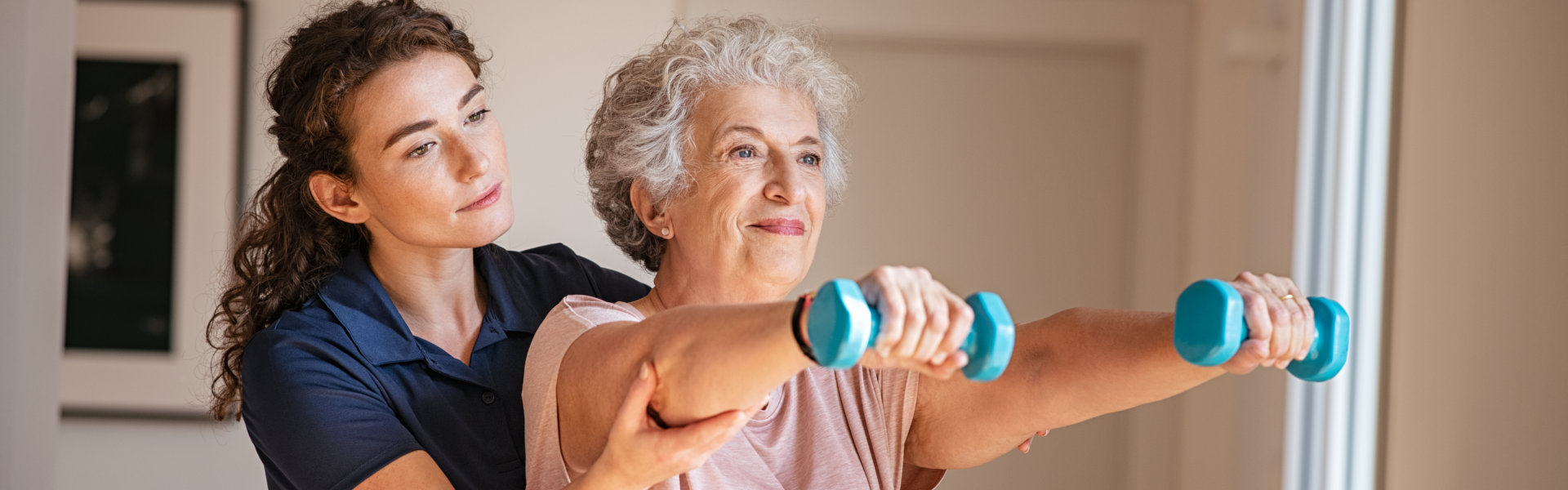 aide assisting elderly in exercising