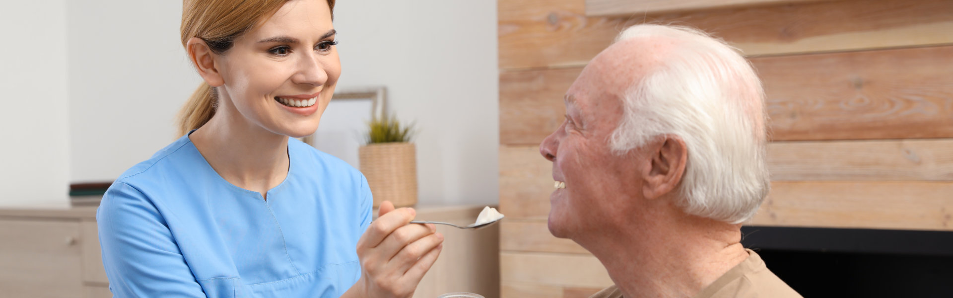 aide feeding an elderly man