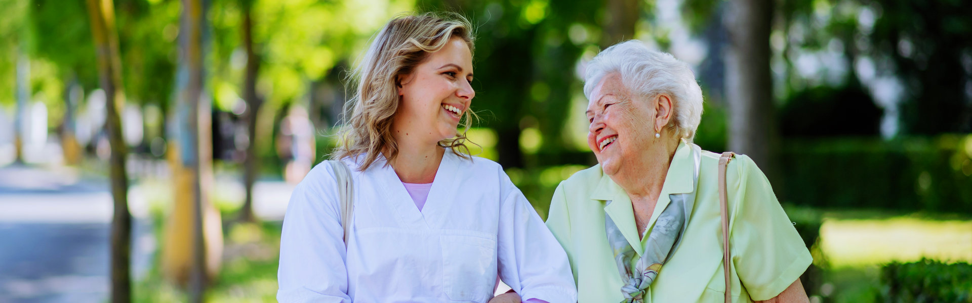 aide and elderly woman smiling at each other